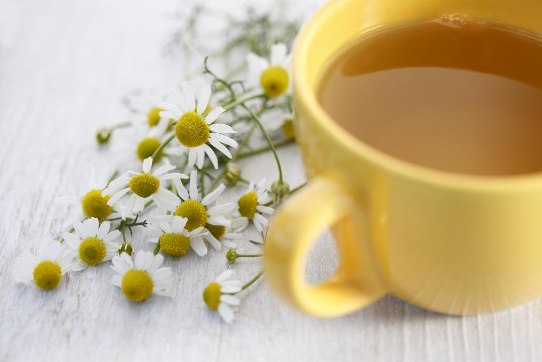 secangkir teh chamomile dengan bunga chamomile