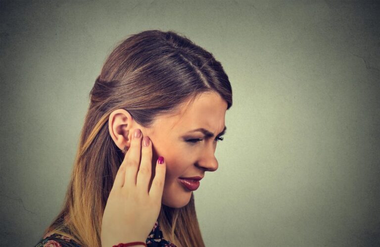 Wanita memegang telinga kerana jangkitan telinga kronik