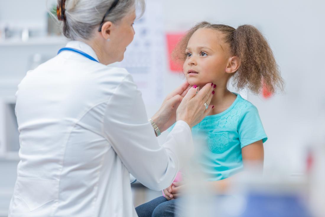 doktor memeriksa leher kanak-kanak perempuan
