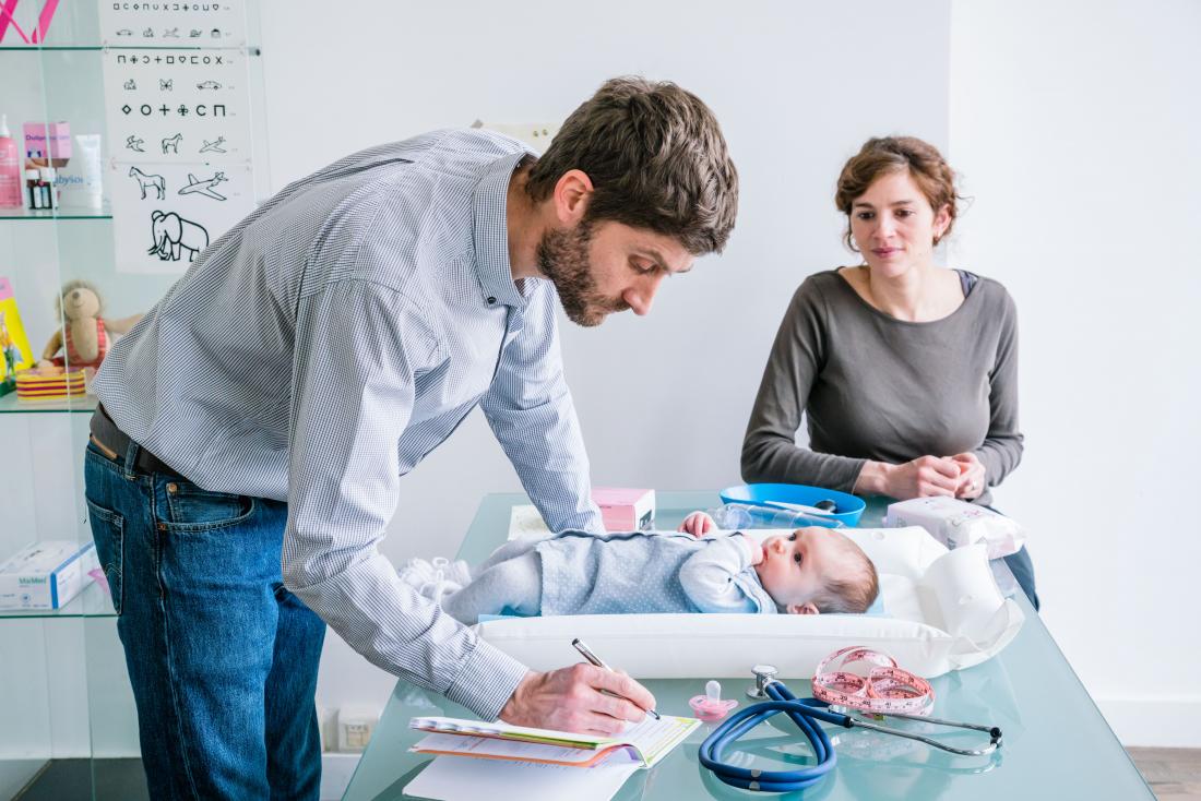 Doktor menaksir bayi di pejabat pediatrik.