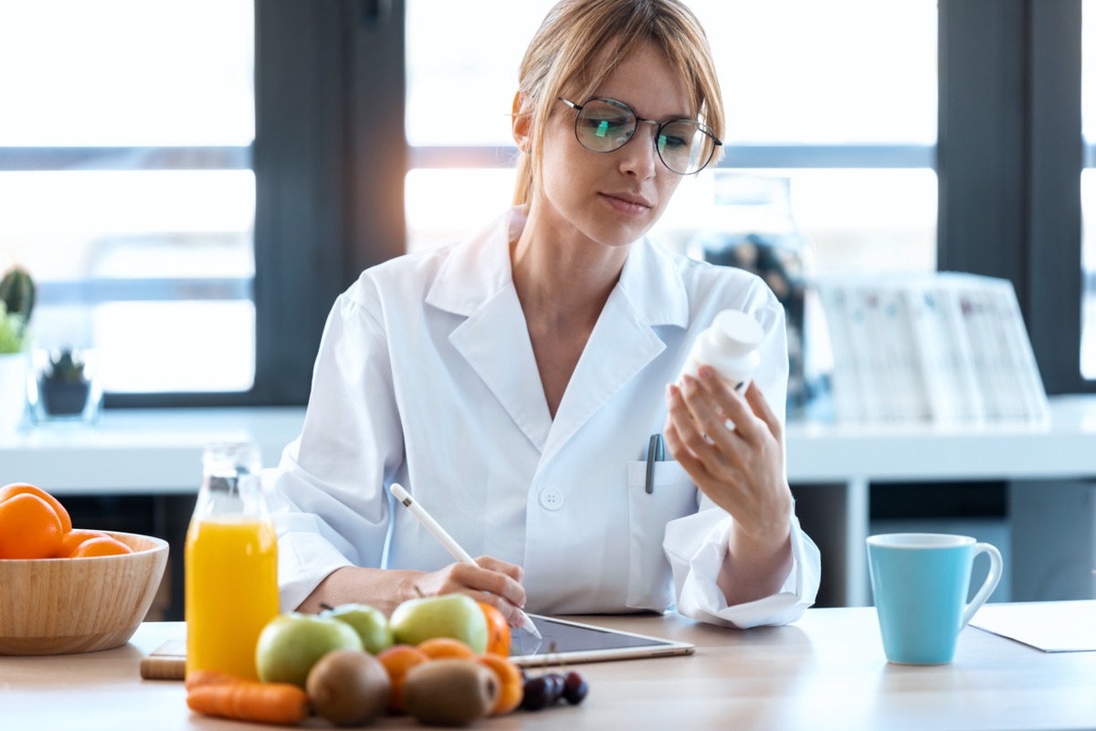 doktor pakar pemakanan wanita menulis preskripsi perubatan untuk diet yang betul